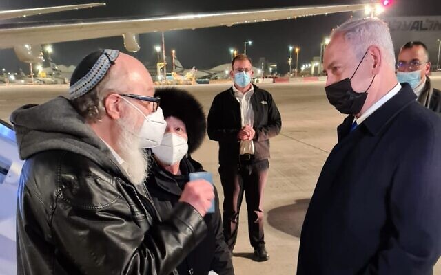 El entonces primer ministro Benjamin Netanyahu (der.) saluda al espía liberado de Israel Jonathan Pollard y a su esposa Esther en el aeropuerto Ben Gurion, el 30 de diciembre de 2020 (Cortesía)