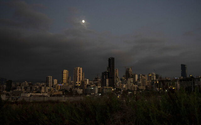 La luna se eleva sobre la ciudad capital de Beirut mientras permanece en la oscuridad durante un corte de energía, Líbano, el jueves 19 de agosto de 2021. (AP/ Hassan Ammar)