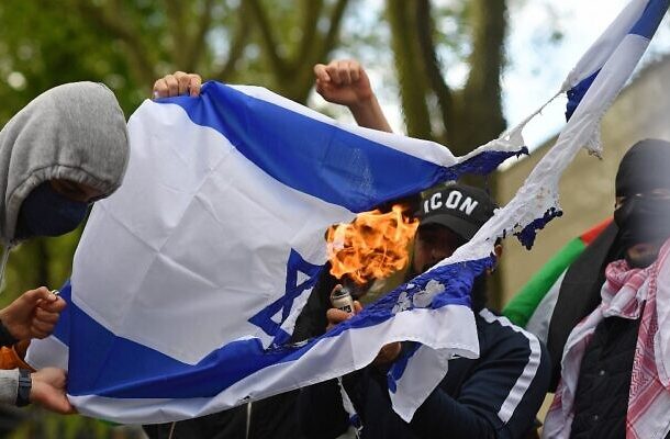 Ilustrativo: activistas y simpatizantes pro palestinos queman una bandera israelí mientras se manifiestan en apoyo de la causa palestina frente a la embajada de Israel en el centro de Londres el 22 de mayo de 2021. (Justin Tallis/AFP)
