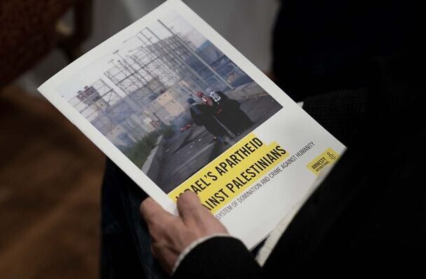 Un periodista sostiene una copia del informe de Amnistía Internacional "El apartheid de Israel contra los palestinos", en Jerusalén, el 1 de febrero de 2022. (Foto AP/Maya Alleruzzo)
