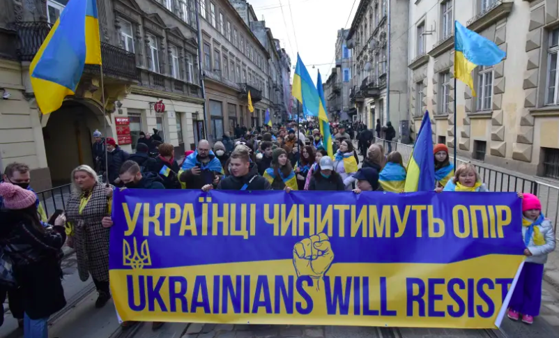 La gente participa en la Marcha de la Unidad, que es una procesión para demostrar el espíritu patriótico de los ucranianos en medio de las crecientes tensiones con Rusia, en Lviv, Ucrania, el 19 de febrero de 2022. (Crédito de la foto: REUTERS/PAVLO PALAMARCHUK)