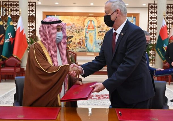 El ministro de Defensa, Benny Gantz, a la derecha, y el ministro de Asuntos de Defensa de Bahrein, Abdullah Bin Hassan Al Nuaimi, se dan la mano después de firmar un memorando de entendimiento en la sede de defensa de Bahrein el 3 de febrero de 2022. (Ariel Hermoni/Ministerio de Defensa)