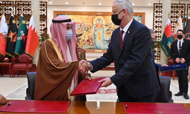El ministro de Defensa, Benny Gantz, a la derecha, y el ministro de Asuntos de Defensa de Bahrein, Abdullah Bin Hassan Al Nuaimi, se dan la mano después de firmar un memorando de entendimiento en la sede de defensa de Bahrein el 3 de febrero de 2022. (Ariel Hermoni/Ministerio de Defensa)