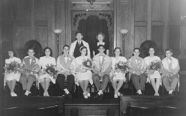 La clase de graduados de la escuela hebrea de SAJ de 1945, con Judith Kaplan Eisenstein, la hija del fundador de SAJ, el rabino Mordecai Kaplan, quien también tuvo el primer bat mitzvah en los EE. UU., y su esposo, el rabino Ira Eistenstein. (Cortesía/a través de JTA)