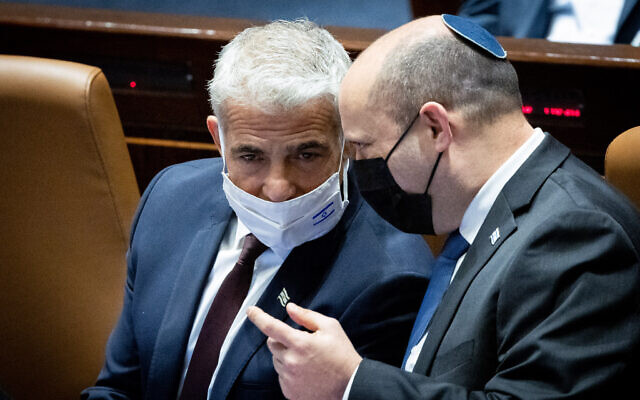 El primer ministro Naftali Bennett (R) y el ministro de Relaciones Exteriores Yair Lapid en el pleno de la Knesset, 5 de enero de 2022. (Yonatan Sindel/Flash90)