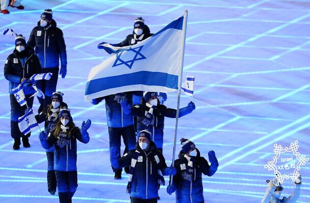 Evgeni Krasnopolski y Noa Szollos, de Israel, llevan su bandera nacional al estadio durante la ceremonia inaugural de los Juegos Olímpicos de Invierno de 2022, el viernes 4 de febrero de 2022 en Beijing. (Foto AP/Matt Slocum)