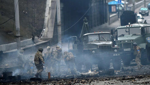 Miembros del servicio ucraniano recogen proyectiles sin explotar en Kiev, capital de Ucrania. (AFP)