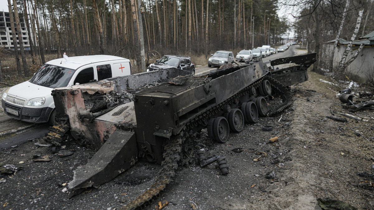 Unos coches pasan por delante de un tanque ruso destruido mientras un convoy de vehículos que evacúan a los civiles sale de Irpin, en las afueras de Kiev, Ucrania, el 9 de marzo de 2022. (AP Photo/Vadim Ghirda, Archivo)