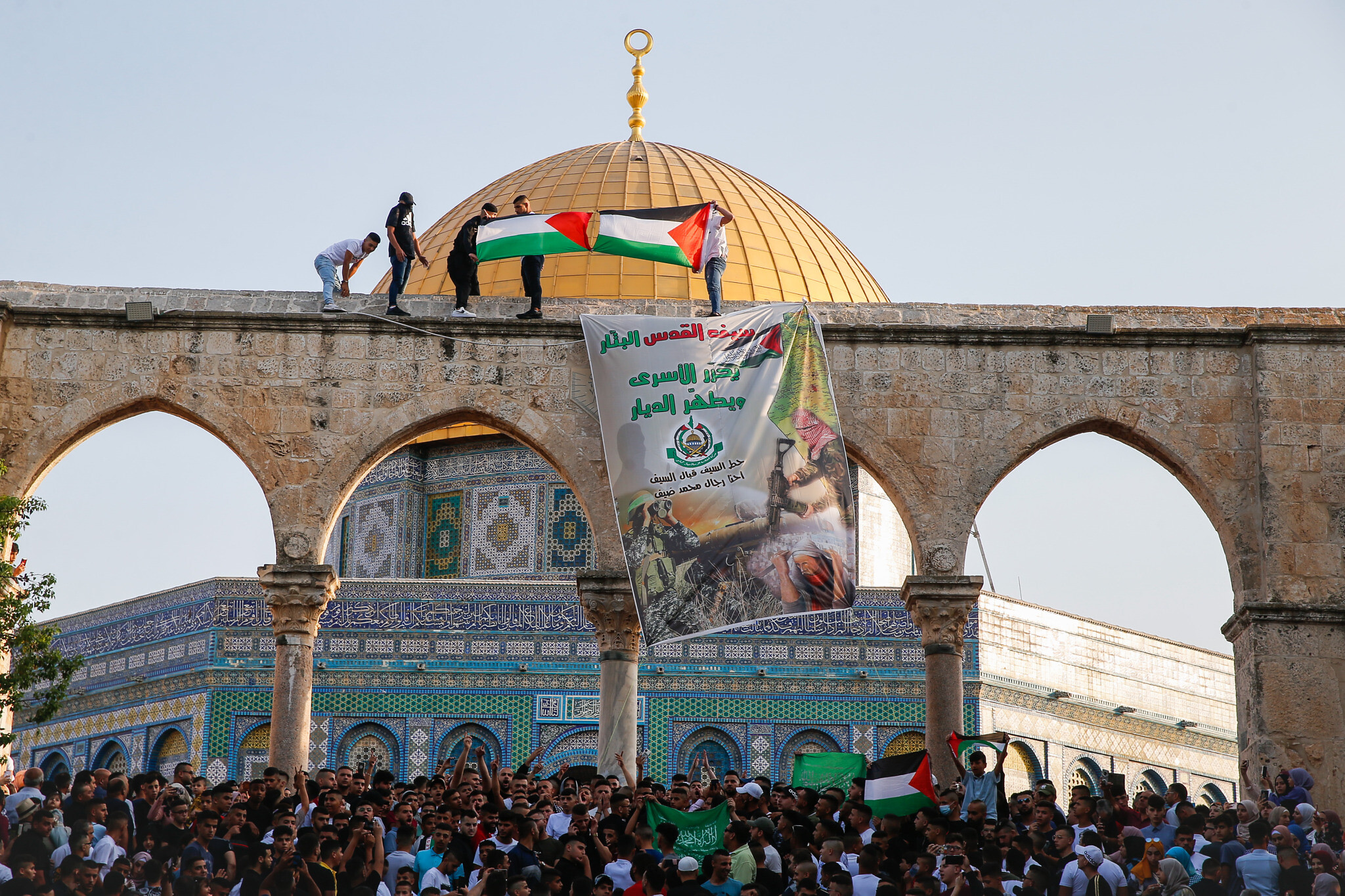 Los fieles levantan la bandera palestina y una pancarta de Hamas después de las oraciones de Eid al-Adha en el Monte del Templo, 20 de julio de 2021. (Jamal Awad/Flash90)