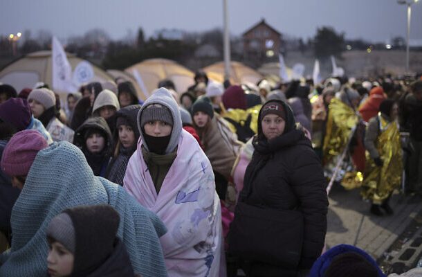 Refugiados esperan en una multitud por transporte después de huir de Ucrania y llegar al cruce fronterizo en Medyka, Polonia, el 7 de marzo de 2022. (AP Photo/Markus Schreiber)