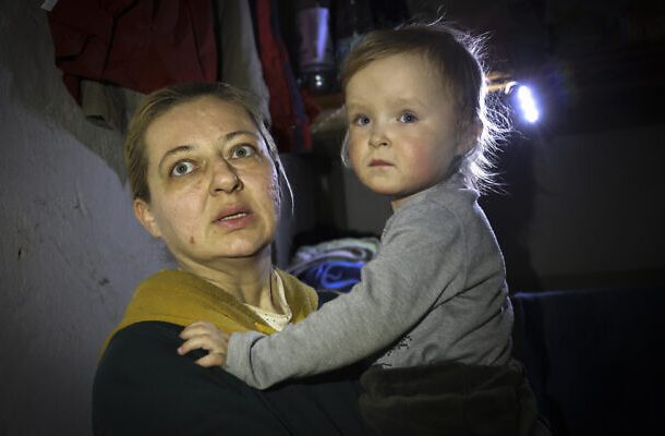 Una mujer sostiene a su hijo mientras habla con un fotógrafo en el sótano de un edificio dañado durante un combate utilizado como refugio antiaéreo en Mariupol, en el territorio que ahora está bajo el control del Gobierno de la República Popular de Donetsk, el 8 de abril de 2022. (Foto AP/Alexei Alexandrov)