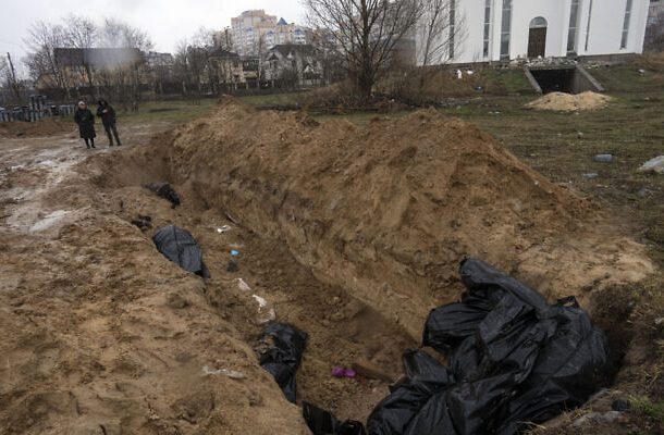 Los vecinos se reúnen junto a una fosa común en Bucha, en las afueras de Kiev, Ucrania, el 3 de abril de 2022. (Foto AP/Rodrigo Abd)
