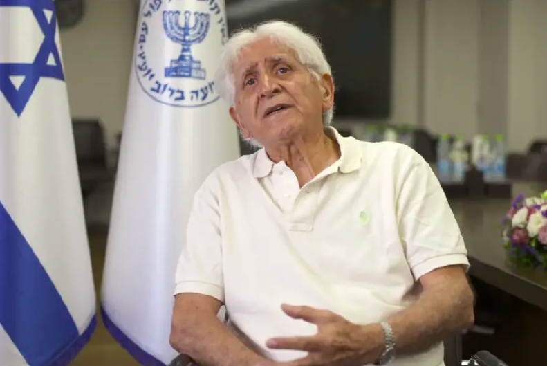 El agente del Mossad, Chaim Victor Tayar, gesticula en un cuadro tomado de un video en el que comparte su testimonio sobre el Holocausto en el Zikaron Basalon del Mossad en el Día del Recuerdo del Holocausto de 2022. (crédito: CORTESÍA DEL MOSSAD)