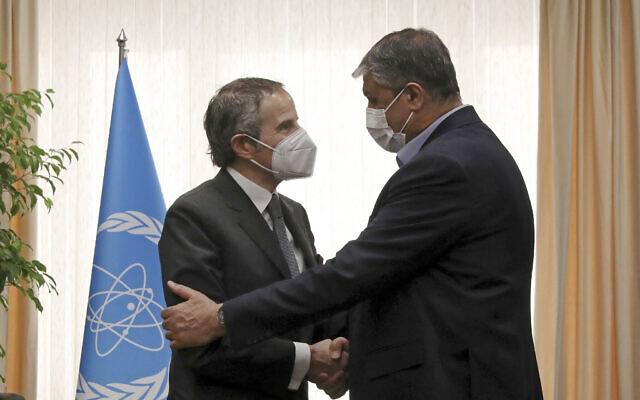 El jefe de la Organización de Energía Atómica de Irán, Mohammad Eslami, a la derecha, y el director general de la Agencia Internacional de Energía Atómica, Rafael Mariano Grossi, se dan la mano al comienzo de su reunión en Teherán el 5 de marzo de 2022. (AP Photo/Vahid Salemi)