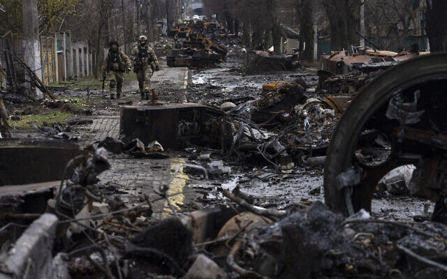 Soldados caminan entre tanques rusos destruidos en Bucha, en las afueras de Kiev, Ucrania, el domingo 3 de abril de 2022. (Foto AP/Rodrigo Abd)