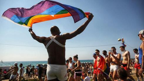 Un manifestante ondea la bandera del orgullo LGBT durante un desfile del orgullo gay en Tel Aviv. (Tommy Harpaz)