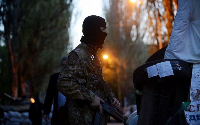 Un hombre armado prorruso con uniforme militar hace guardia frente al edificio regional del servicio de seguridad (SBU) en la ciudad de Slavyansk, en el este de Ucrania, el 25 de abril de 2014. (AFP/Kirill Kudryavtsev)