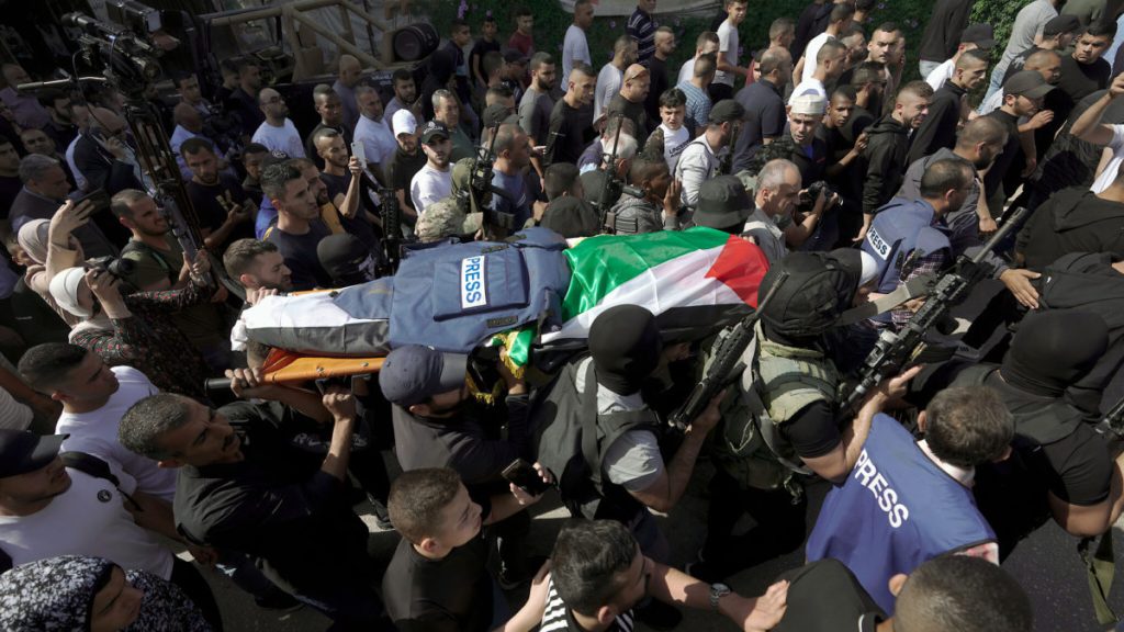 Militantes palestinos llevan el cuerpo de Shireen Abu Akleh, periodista de la cadena Al Jazeera, al depósito de cadáveres dentro del Hospital de la ciudad de Jenin, el 11 de mayo de 2022. (AP Photo/Majdi Mohammed)