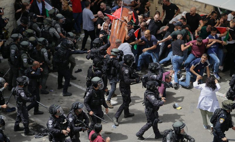 La policía israelí confronta a los dolientes mientras transportan el ataúd de la periodista de Al Jazeera asesinada Shireen Abu Akleh, casi derribándolo, durante su funeral en Jerusalén, el 13 de mayo de 2022. (Foto AP/Maya Levin)