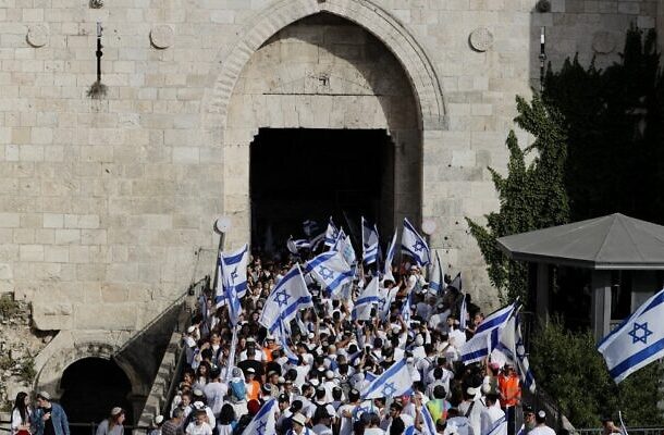 Los judíos que participan en la Marcha de las Banderas pasan por la Puerta de Damasco hacia la Ciudad Vieja de Jerusalén el 29 de mayo de 2022, cuando Israel conmemora el Día de Jerusalén. (Ahmad Gharabli/AFP)
