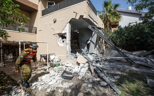 Un soldado del Comando del Frente Nacional del ejército israelí camina frente a una casa en la ciudad de Ashkelon, en el sur de Israel, que fue alcanzada por un cohete de Hamas el 20 de mayo de 2021. (Edi Israel/Flash90)