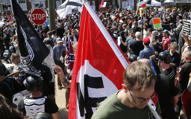 Ilustrativo: un supremacista blanco que porta una bandera nazi en el Parque de la Emancipación en Charlottesville, Virginia, el 12 de agosto de 2017. (AP/Steve Helber/Archivo)