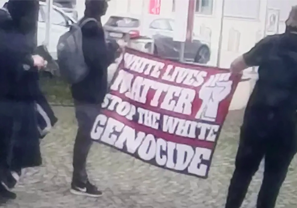 Radio Jai -Los hombres llevan una pancarta de extrema derecha en una manifestación frente a la sinagoga de Ulm, Alemania, junio. 5, 2022. (Cortesía de la Comunidad Religiosa Judía de Württemberg)
