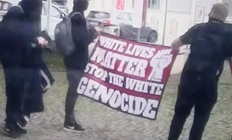 Radio Jai -Los hombres llevan una pancarta de extrema derecha en una manifestación frente a la sinagoga de Ulm, Alemania, junio. 5, 2022. (Cortesía de la Comunidad Religiosa Judía de Württemberg)