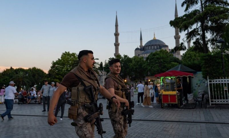 Agentes de la policía antidisturbios turcos caminan frente a la Mezquita Azul en Estambul el 14 de junio de 2022. (Yasin Akgul/AFP)