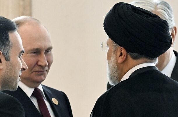 El presidente ruso, Vladimir Putin, a la izquierda, habla con el presidente de Irán, Ebrahim Raisi, de espaldas a una cámara, al margen de la cumbre de los estados ribereños del Mar Caspio en Ashgabat, Turkmenistán, el 29 de junio de 2022. (Grigory Sysoyev, Sputnik, Kremlin Pool Photo vía AP, Archivo)