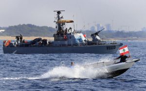 Radio Jai -Manifestantes libaneses en una lancha a motor llevan su bandera nacional mientras navegan frente a un barco de la Armada israelí durante una manifestación que respalda los reclamos del Líbano sobre campos marítimos de petróleo y gas en disputa, cerca de la ciudad fronteriza sur de Naqoura, Líbano, el 4 de septiembre de 2022. (AP /Mohammed Zaatari)