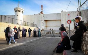 Radio Jai - Las fuerzas de seguridad israelíes vigilan mientras los palestinos atraviesan un puesto de control israelí cerca de la ciudad cisjordana de Belén, el 22 de abril de 2022. (Wisam Hashlamoun/Flash90)