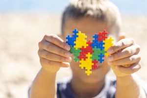 Radio Jai -Un niño sostiene un colorido corazón de rompecabezas frente a su rostro para crear conciencia sobre el Día Mundial del Autismo. (iStock a través de Getty Images)