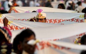 Radio Jai -Un novio se para detrás de una sábana con la esvástica hindú durante un ritual en una ceremonia de boda masiva en Virar, en las afueras de Mumbai, India, el 29 de enero de 2012. (Rajanish Kakade/AP)