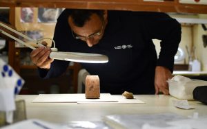 Radio Jai -Amir Ganor, director del Proyecto de Excavación de las Cuevas de Muraba'at, examina la caja de 2200 años de antigüedad. (Yoli Schwartz, Autoridad de Antigüedades de Israel)