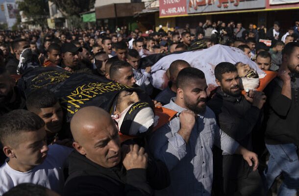 Radio Jai -Los dolientes palestinos llevan los cuerpos de Naeem Jamal Zubaidi, de 27 años, a la izquierda, y Mohammad Ayman Saadi, de 26, cubiertos con banderas del Movimiento de la Yihad Islámica, durante su funeral en la ciudad cisjordana de Jenin, el jueves 1 de diciembre de 2022. (AP Foto/Nasser Nasser)