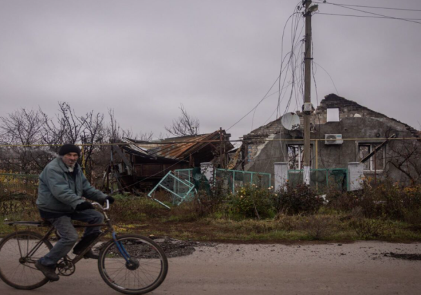 Radio Jai -Un hombre pasa en bicicleta frente a una casa destruida en el pueblo de Posad Pokrovske, en las afueras de Kherson, Ucrania, el 30 de noviembre de 2022. (Chris McGrath/Getty Images)