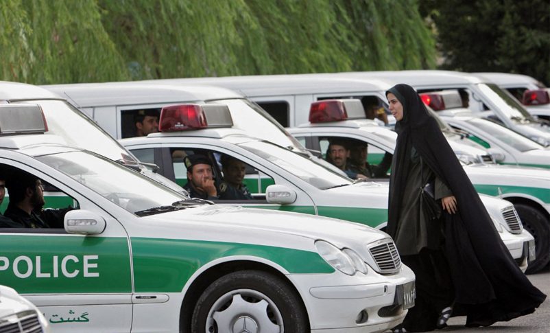 Radio Jai -Archivo: Una mujer policía de moralidad iraní camina entre los vehículos de la policía de moralidad, preparándose para iniciar una represión para hacer cumplir el código de vestimenta islámico en Teherán, 23 de julio de 2007. (Behrouz Mehri/AFP)